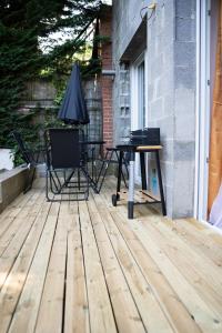 a patio with a table and chairs on a deck at Le Bathalzar in Villeneuve d'Ascq