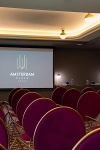 a conference room with purple chairs and a screen at Amsterdam Plaza Hotel & SPA in Palanga