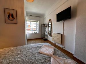 a bedroom with a bed and a flat screen tv at AtuaireHome Hostal en el centro de Burgos in Burgos