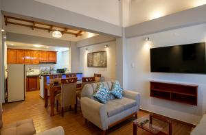a living room with a couch and a television on a wall at Departamento con Vista a la Ciudad in Cusco