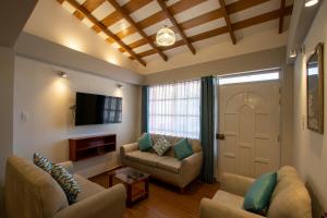 a living room with two couches and a tv at Departamento con Vista a la Ciudad in Cusco