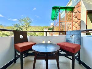 un balcone con due sedie e un tavolo di Shelton Blu Resort Jim Corbett a Ramnagar
