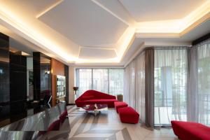 a living room with red furniture and large windows at Amsterdam Plaza Hotel & SPA in Palanga