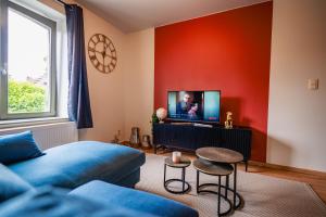 a living room with a blue couch and a tv at Appartement Tournai Hyper centre in Tournai