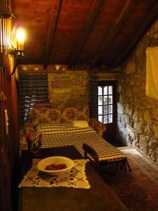 une pièce avec un canapé et une table dans une pièce en pierre dans l'établissement Casa Campo Das Bizarras, à Castro Daire