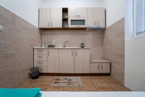 a kitchen with wooden cabinets and a sink at Mrzenci Apartments in Gevgelija