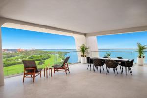 a dining room with a table and chairs and a large window at Hyatt Vivid Grand Island Cancun-All Inclusive Adults Only in Cancún