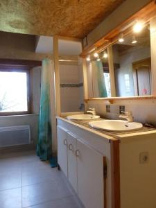 a bathroom with two sinks and a mirror at Maison en éco construction in Piégros-la-Clastre