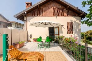 Un patio con una mesa y sillas y una sombrilla. en Il Gelsomino - Terrace Country House, en Pisano