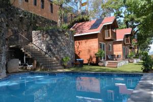 a house with a swimming pool next to a building at Cabañas Jardín de Sebastían in Valle de Bravo