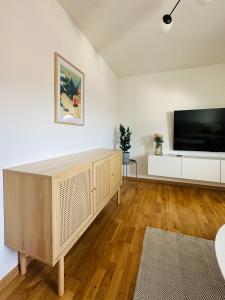 a living room with a large television and a wooden floor at Vyskoč na hory in Nová Lesná
