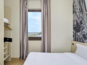 A bed or beds in a room at B&B Hotel Milano-Monza
