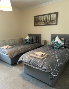 twee bedden naast elkaar in een slaapkamer bij Epworth Cottage in Crich