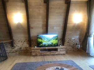 a flat screen tv sitting in a room with wooden walls at Vikendica Aleksandra in Žabljak