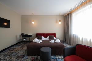a bedroom with a bed and a chair and a desk at Amsterdam Plaza Hotel & SPA in Palanga