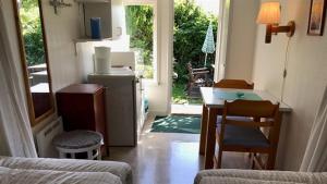 a living room with a table and a kitchen with a door at Strandnära Stuga Anna in Visby +13 photos