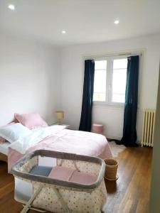 a bedroom with a bed and a window at Maison des Poules Roses in Pierrelaye +17 photos