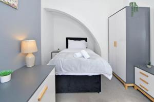 a bedroom with a bed and a desk with a lamp at Holt House - By Sigma Stays in Crewe
