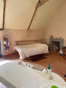 a bedroom with a bed and a table with a book at L'Adventice in Riec-sur-Bélon