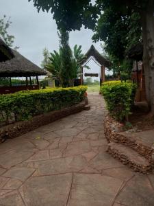 a stone walkway with bushes and a pavilion at Pine Breeze Getaway LUKENYA in Athi River