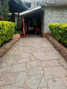 a stone walkway in front of a building at Pine Breeze Getaway LUKENYA in Athi River