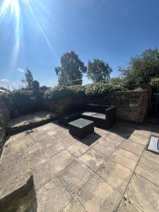 een bank bovenop een patio bij Epworth Cottage in Crich