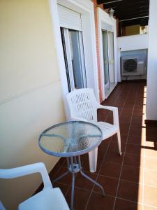 a glass table and two chairs on a balcony at Terrasol Torrelitoral 1 dormitorio in Torre del Mar