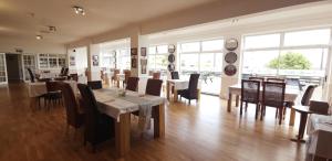 een eetkamer met tafels en stoelen en ramen bij Sunrise Hotel in Shanklin