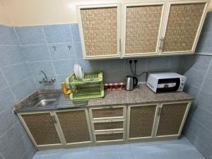 a kitchen counter with a sink and a microwave at العين الهيلي مصباح ب 11 in Al Ain