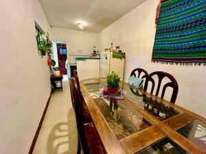 a kitchen with a table and chairs and a refrigerator at Casa De Leon in Antigua Guatemala