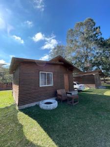 a small house with a bench and a table in the yard at Complejo de Cabañas Ohana Salta in Campo Quijano