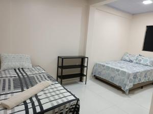 - une chambre avec 2 lits et une table de nuit dans l'établissement Cattarino Dormitórios, à Cristalina 18 autres photos