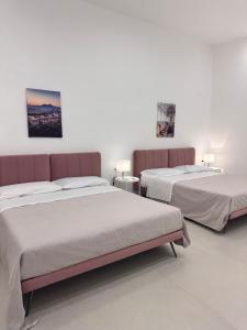 two beds in a white room with two beds at Blu Parthenope a Spaccanapoli in Naples