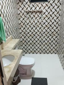 La salle de bains est pourvue de toilettes et d'un mur. dans l'établissement Cattarino Dormitórios, à Cristalina