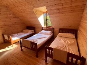 a room with two beds in a log cabin at Te Oli Theth in Theth