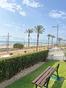 a park bench with a view of the beach at Playa y montaña. 1ª linea. Piscina. Parking . A/C in El Campello