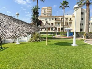 a resort with a grass yard and a building at Playa y montaña. 1ª linea. Piscina. Parking . A/C in El Campello +66 photos