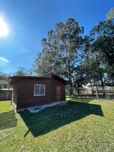 a small house in a grassy yard with a tree at Complejo de Cabañas Ohana Salta in Campo Quijano