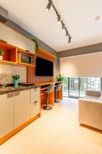 une cuisine ouverte avec une table et une télévision dans l'établissement Apartamentos completos ao lado do metrô, Vila Madalena, à São Paulo