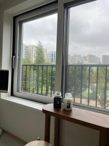 a room with two windows and a table with a candle at Asla stay in Incheon