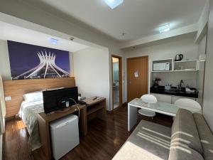 a bedroom with a bed and a desk with a computer at Suite Particular no Hotel S4 Águas Claras in Brasília