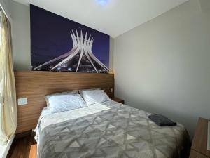 a bedroom with a bed with a picture of a building at Suite Particular no Hotel S4 Águas Claras in Brasília