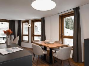 a dining room with a table and chairs and windows at Duplex plein sud à Courchevel Village - 4 pers - Pieds des pistes, balcons, parking, casier à skis - FR-1-631-73 in Courchevel