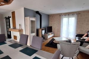 un salon avec un canapé, une table et des chaises dans l'établissement Charmante maison de ville climatisée avec Wifi, à Saint-Yrieix-la-Perche