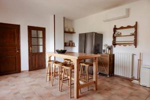 a kitchen with a wooden table and stools at Mount Minis - Casa Bruno in Syvota