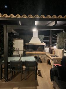 a patio with a table and chairs and a stove at Апартаменты в Вари in Vari