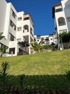 a group of white buildings with a grassy hill at Serene & Joyful Retreat - Breathtaking view in Cabo Negro