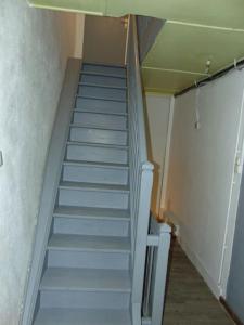 un escalier dans une pièce avec une cage d'escalier dans l'établissement Location de vacances au cœur du Pilat, à Jonzieux