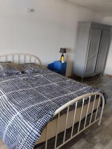 - un lit avec une couverture en damier dans l'établissement Location de vacances au cœur du Pilat, à Jonzieux