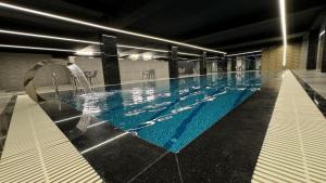 a large swimming pool with blue water in a building at MyFlower 3 Hotel in Erbil